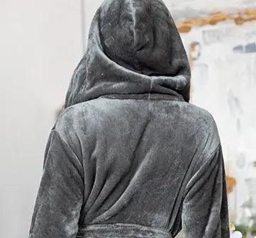 Person wearing a gray hooded robe with a blurred background. Vicsxox.com