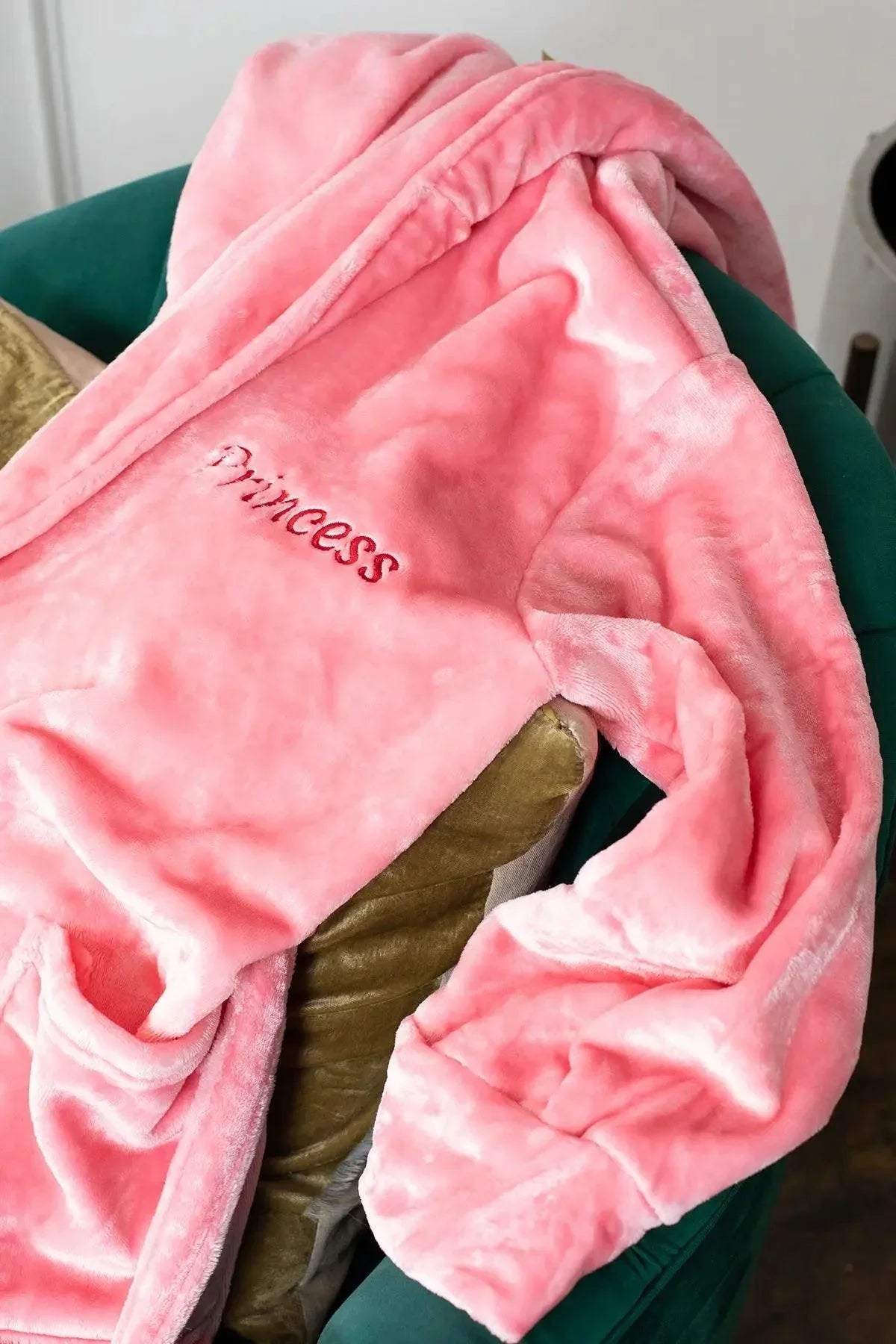 Pink plush blanket with 'Princess' embroidery on a green chair. Vicsxox.com