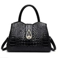 Black crocodile-patterned handbag with a gold emblem on a white background