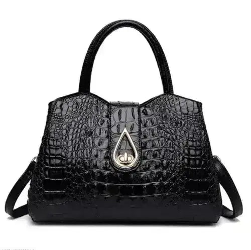 Black crocodile-patterned handbag with a gold emblem on a white background