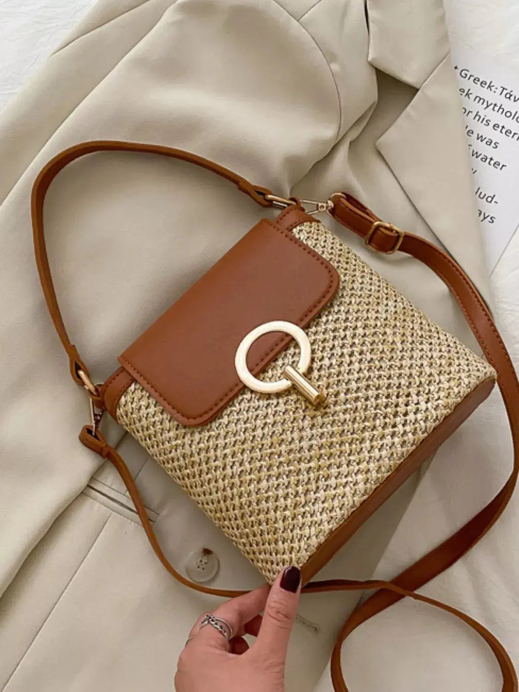 Woven straw crossbody bag with leather flap, front view Vicsxox.com