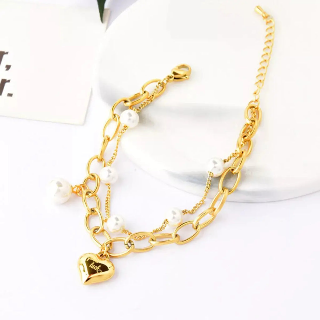 Woman wearing gold pearl heart charm bracelet