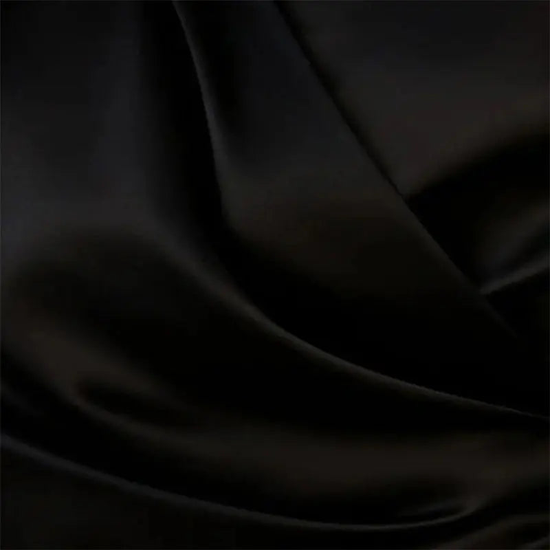 Black satin fabric with folds and shadows