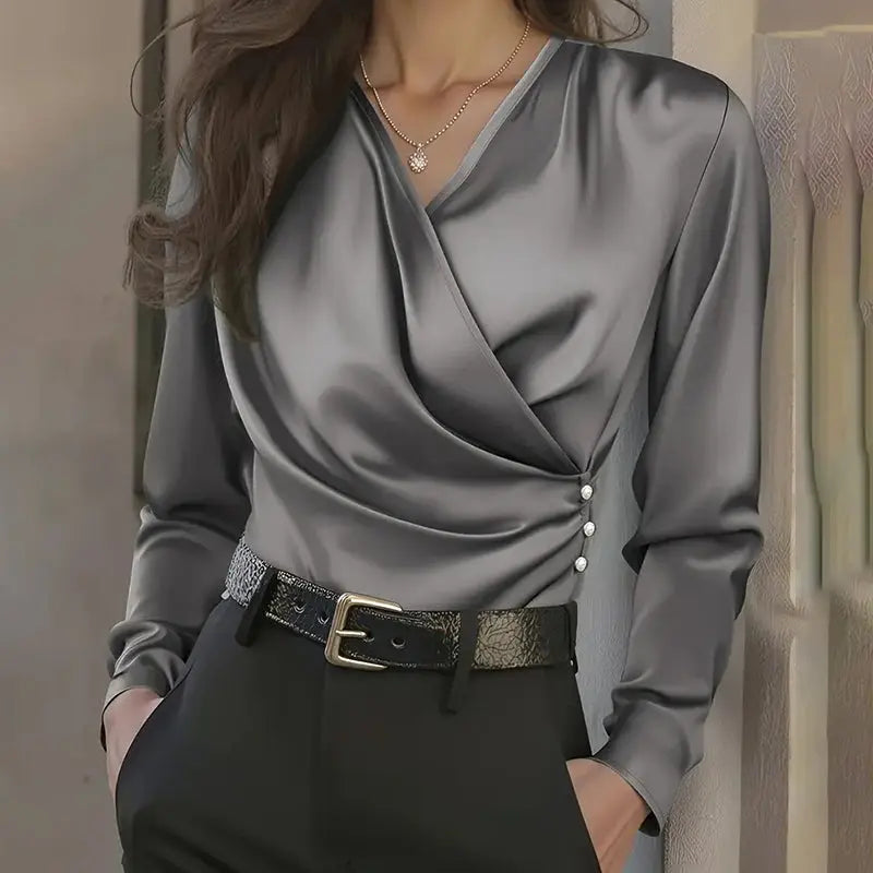 Gray satin blouse with a belt worn by a person against a neutral background
