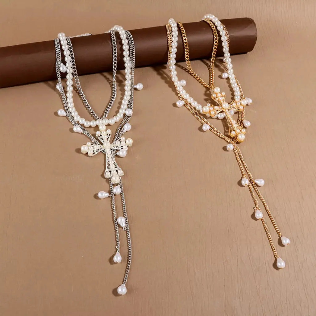 Woman wearing layered pearl cross necklace set
