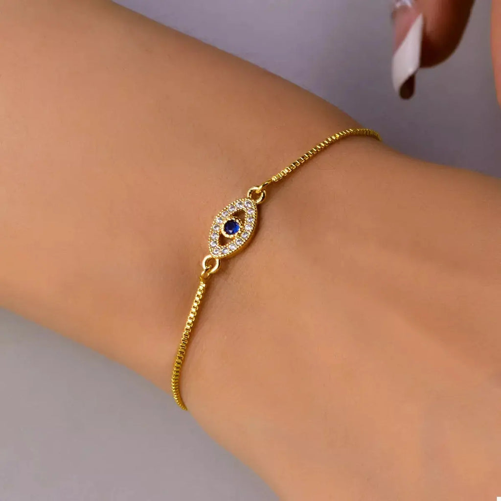Close-up of evil eye charm on gold bracelet