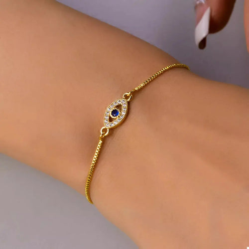Close-up of evil eye charm on gold bracelet