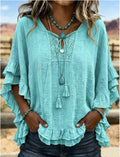 Teal blouse with ruffled sleeves and lace details worn by a person outdoors.
