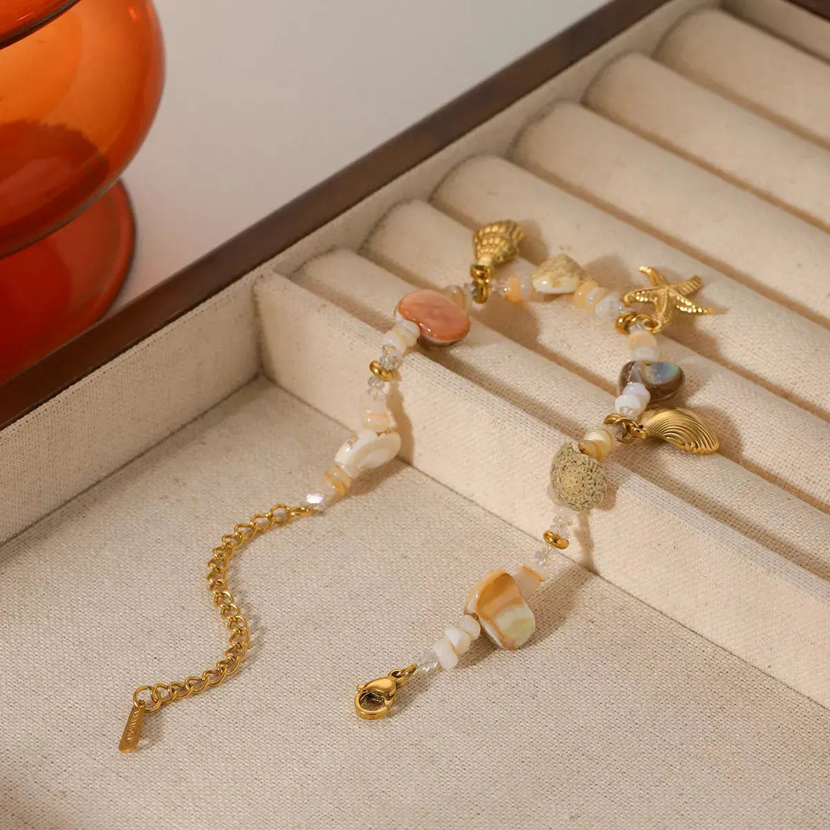 Woman wearing gold shell charm bracelet