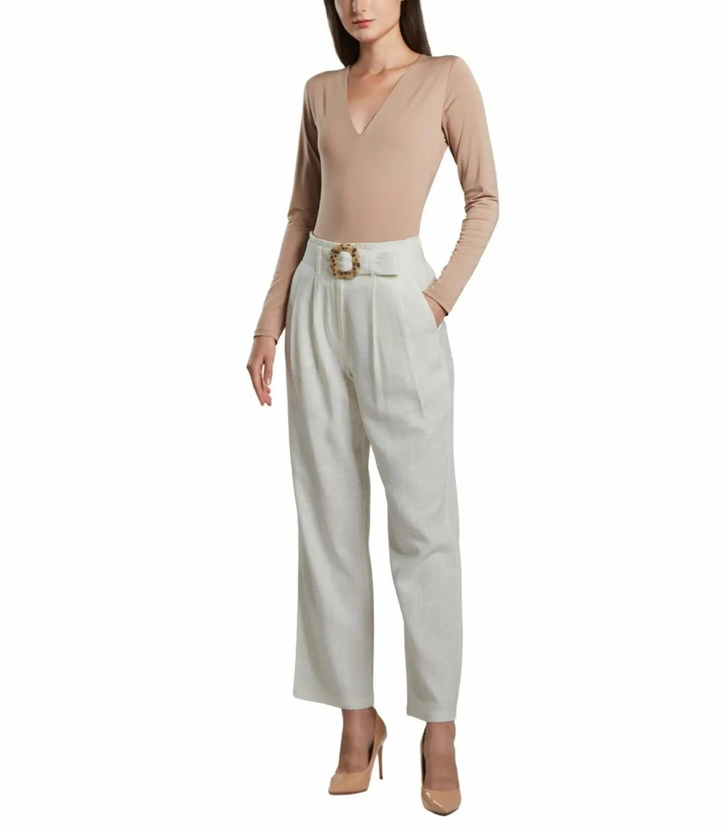 Woman wearing a beige bodysuit and white pants with a belt on a white background