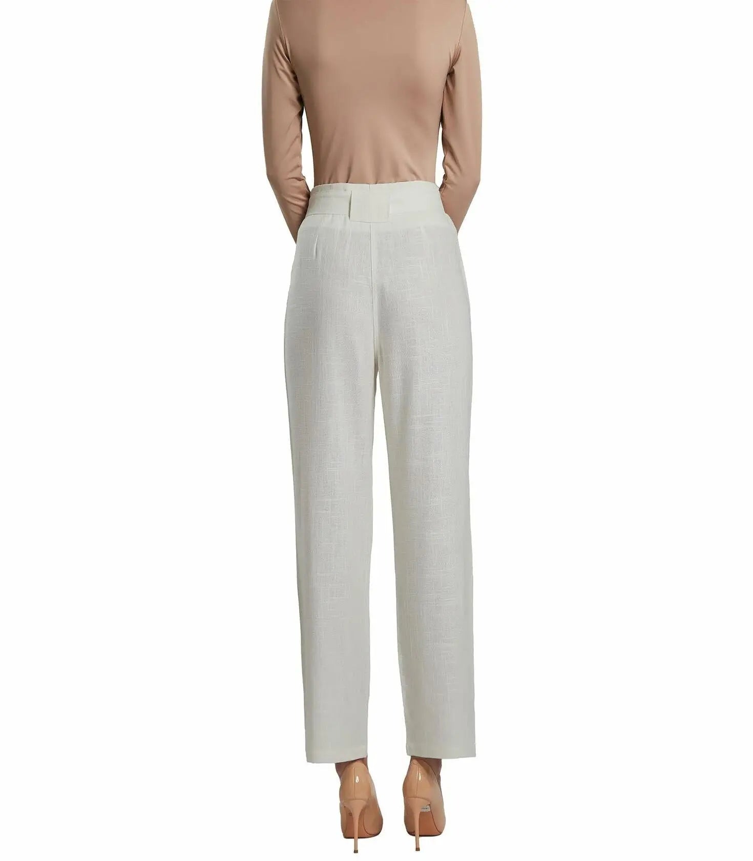 Person wearing a beige top and light gray pants on a white background