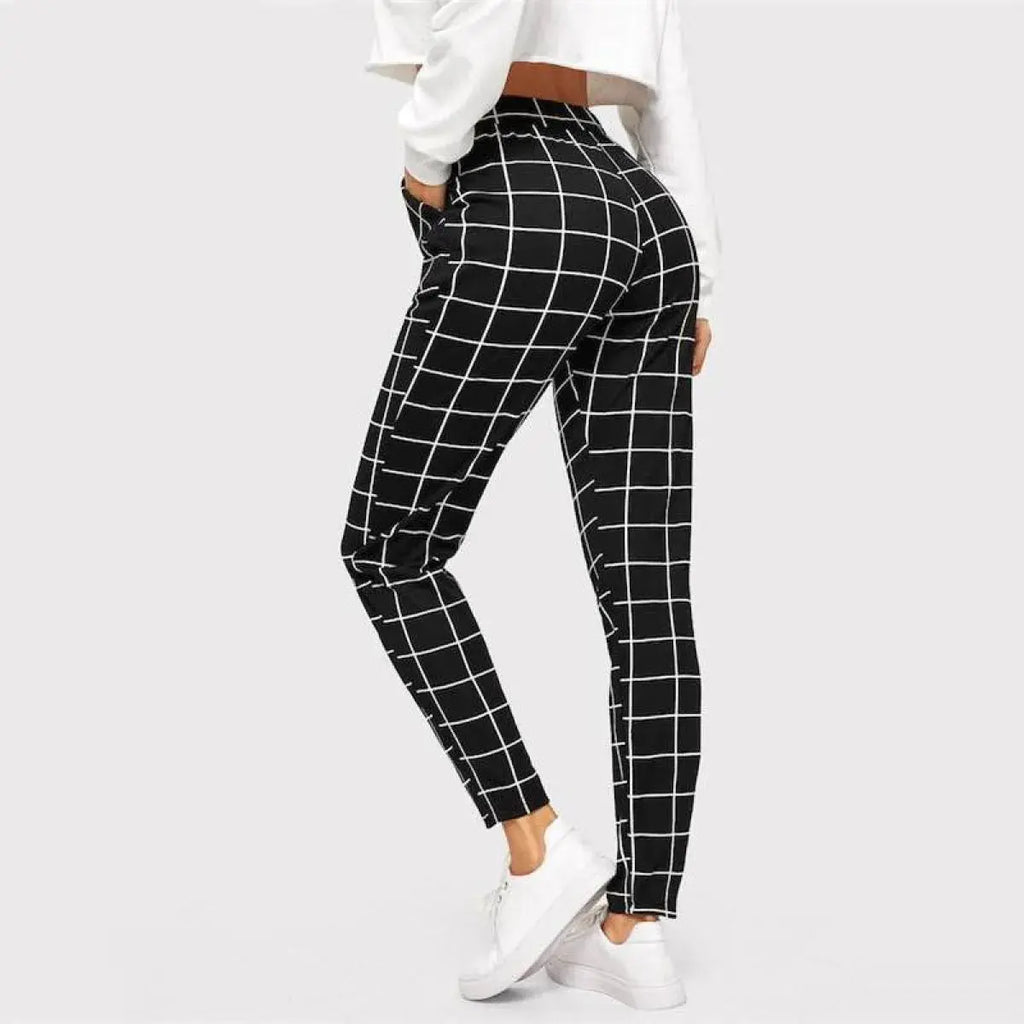 Black and white checkered pants worn by a person on a light gray background