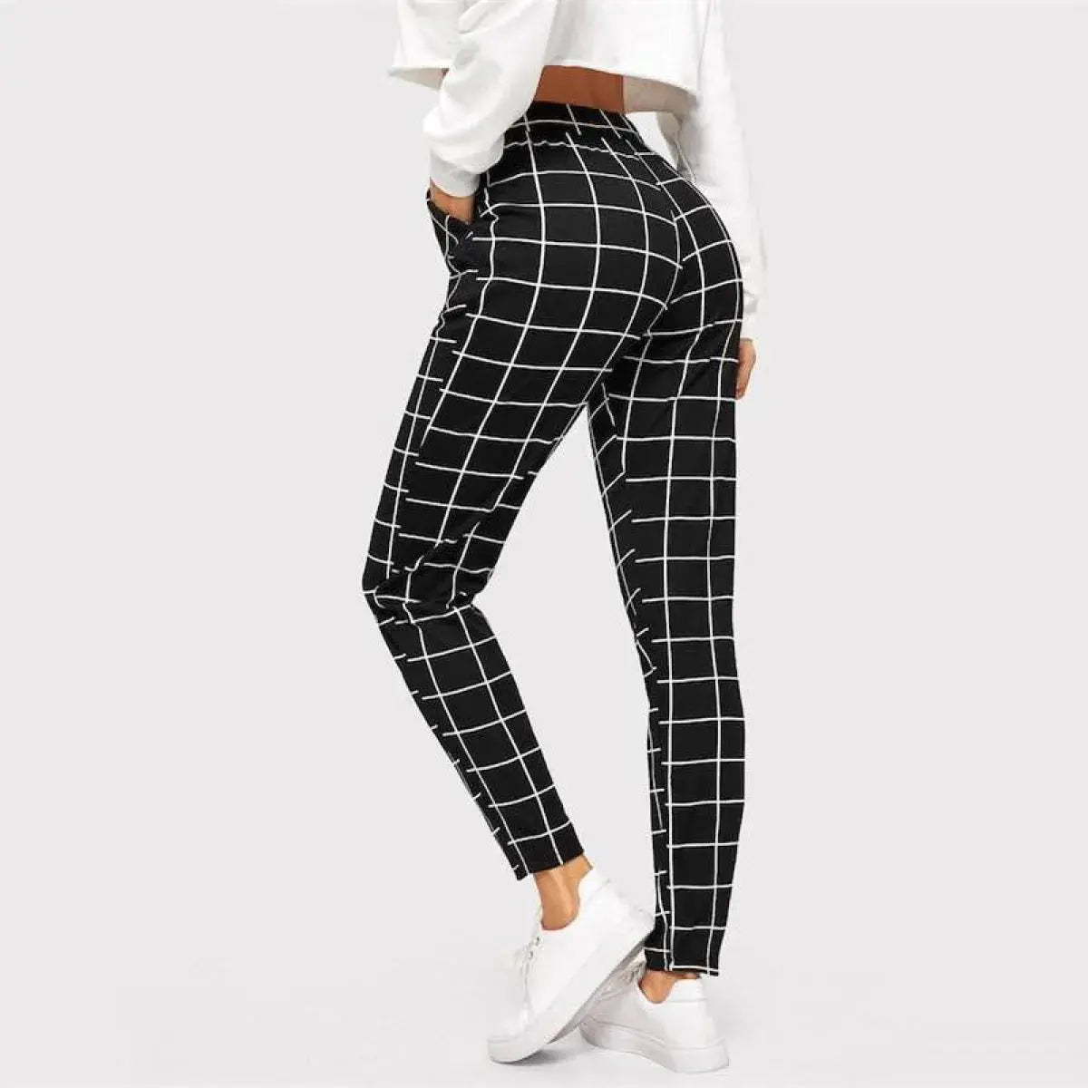 Black and white checkered pants worn by a person on a light gray background