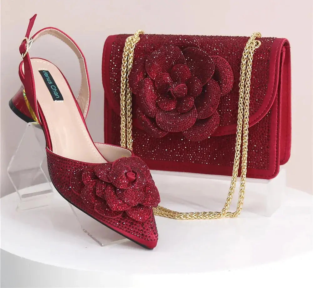 Red high-heeled shoes and matching handbag with floral design on a white background