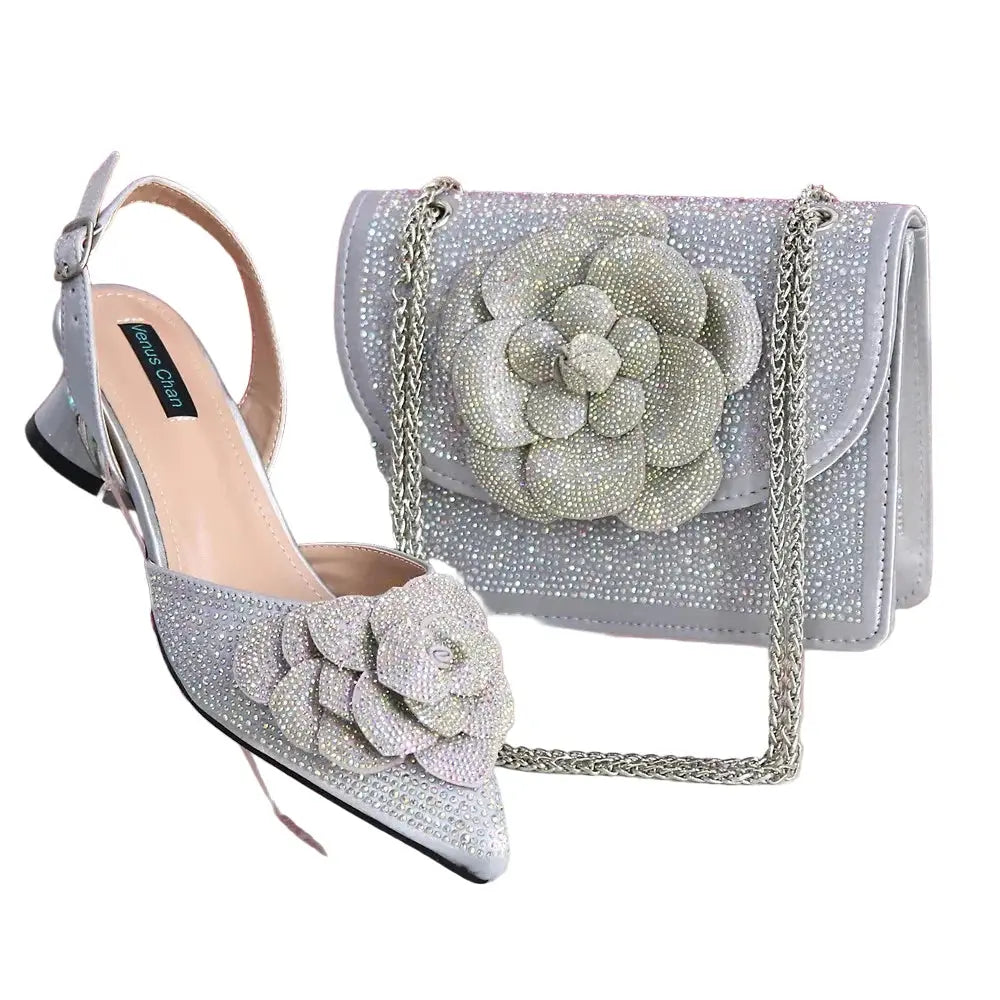 Silver high-heeled shoes and matching handbag with floral design on a white background