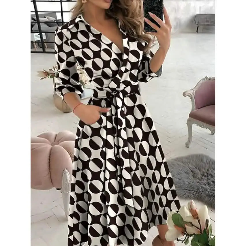 Woman wearing a black and white patterned dress in a room with furniture.