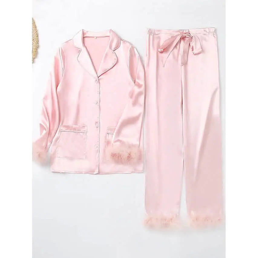 Pink satin pajama set on a white background